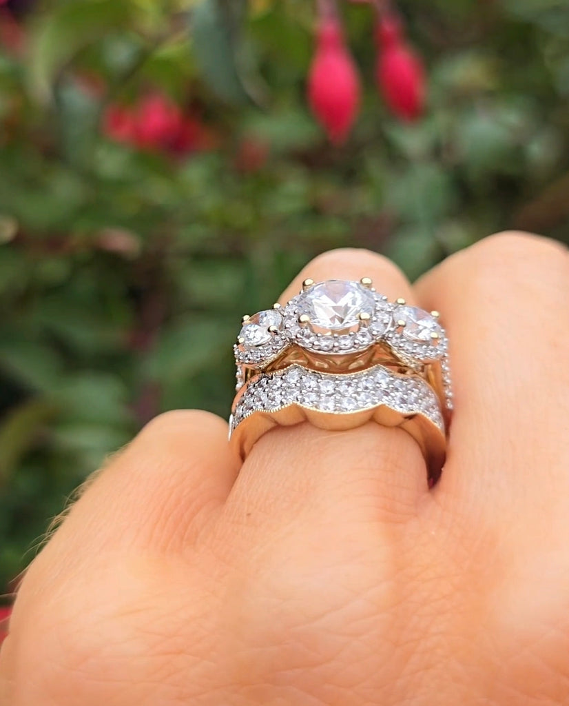 Yellow gold engagement ring with diamonds on a finger against a blurred natural background from gleeson jewellers