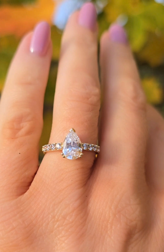 Éirlen 9ct gold pear-shaped cubic zirconia ring by Gleeson Jewellers, worn on the hand, highlighting its teardrop centre stone and sparkling diamond-set shoulders.