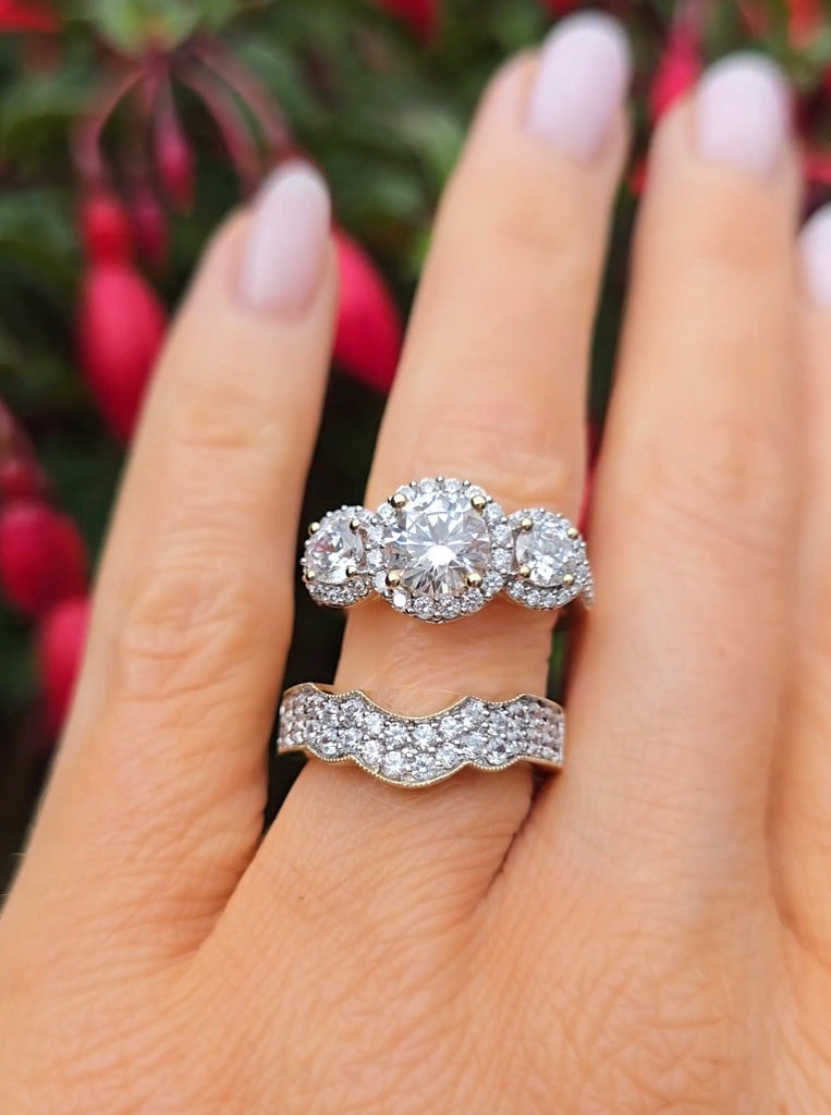 Diamond ring with a matching fitting wedding band on a hand with a blurred natural background from gleeson jewellers 