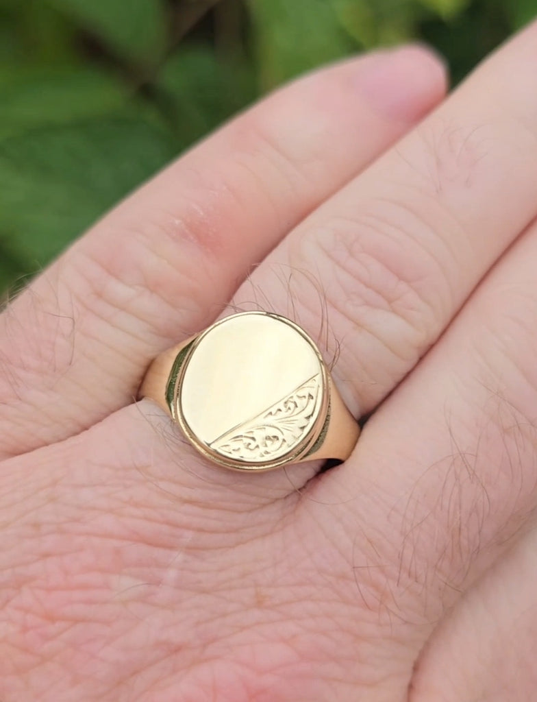 Chunky men's gold signet ring on hand, engraved detail visible – Gleeson Jewellers