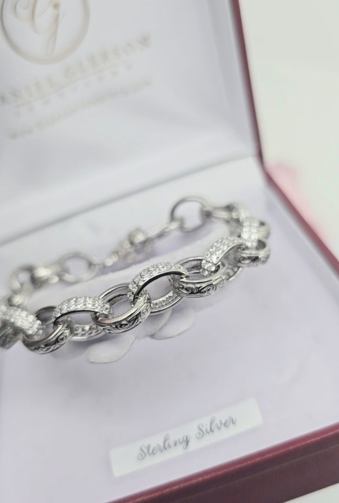 Sterling silver children’s oval link bracelet displayed in a Gleeson Jewellers Cork presentation box, featuring alternating textured and CZ-set links