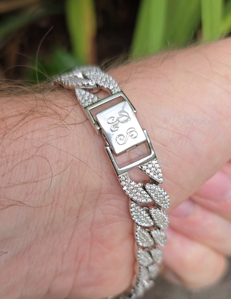 Back view of the bracelet worn on wrist showing engraved clasp with two initials on the polished plate.
