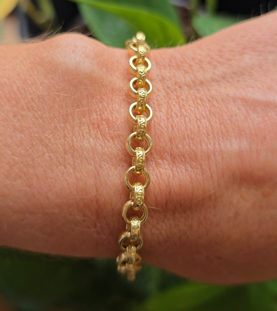 Close-up of a gold on sterling silver patterned belcher-link bracelet on a wrist, highlighting the polished 6 mm links