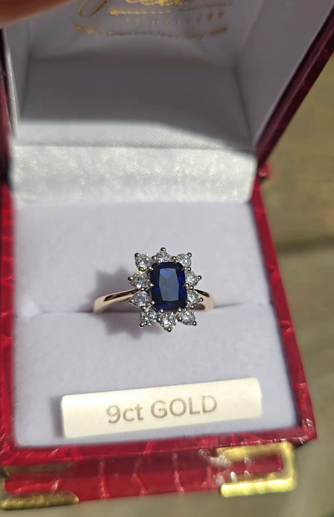 The sapphire cluster ring displayed in a red Gleeson Jewellers box with “9ct GOLD” label visible.