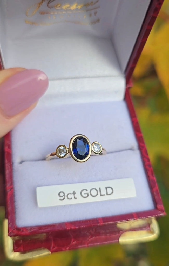 Gold ring with a blue gemstone in a gleeson jewellers jewelry box