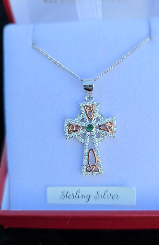 Sterling silver Celtic cross pendant with emerald centerpiece and rose gold trinity knot accents, crafted by Daniel Gleeson Jewellers, front view