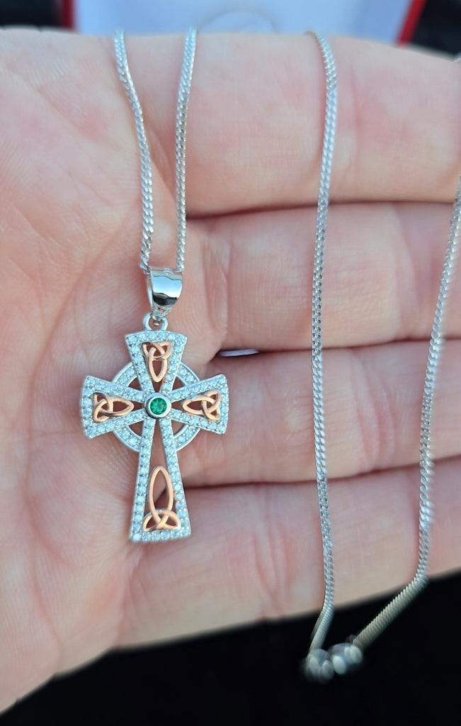 Celtic cross pendant held in hand for size reference, showcasing the pendant’s elegant detailing and craftsmanship