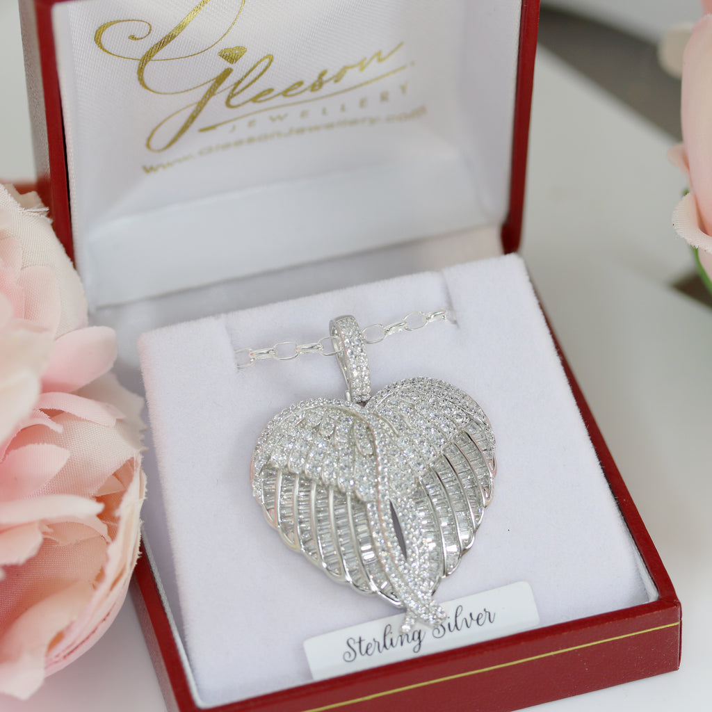 Sterling silver cubic zirconia angel wing pendant resting in a gift-ready jewellery box, showcasing its intricate wing and heart design.