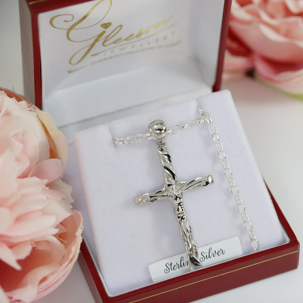 Sterling silver textured crucifix pendant displayed in a red and white luxury jewellery box, featuring an intricate design of Christ on the cross