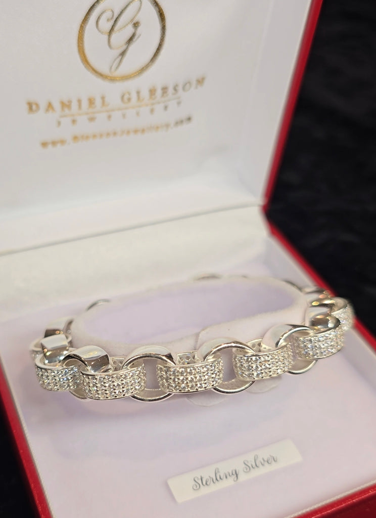 A close-up view of the Large Sterling Silver Ladies Belcher Bracelet from Daniel Gleeson Jewelers displayed in an elegant jewelry box, showcasing its polished links and sparkling cubic zirconia accents against a soft, plush interior.