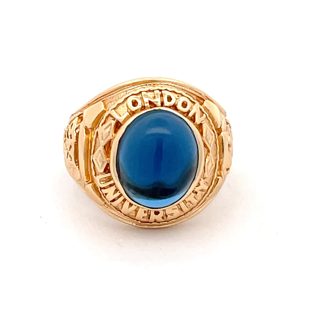 Overhead view of sterling silver gold-plated men’s college ring with engraved detailing and deep blue stone from Gleeson Jewellers.