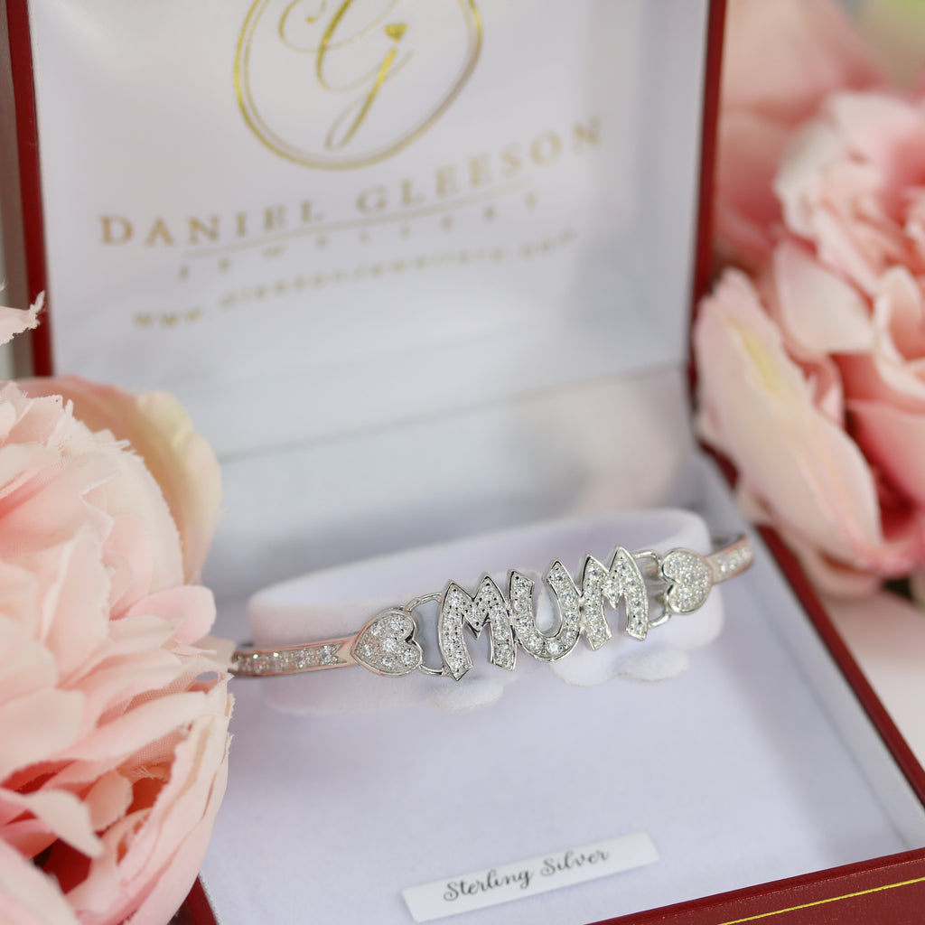 Elegant sterling silver Mum bangle resting in a jewellery box, surrounded by soft pink floral accents, perfect for Mother’s Day gifting.