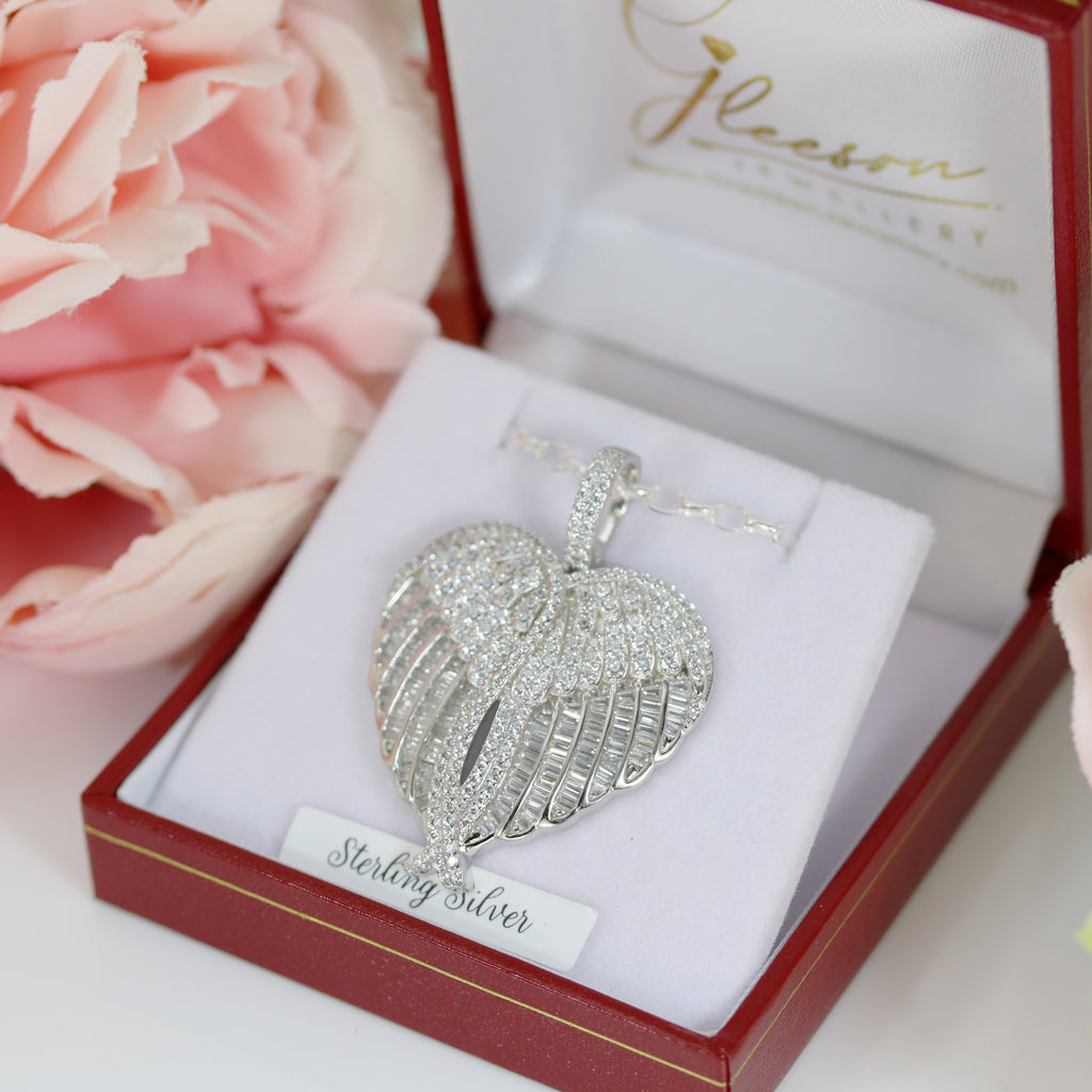 Elegant angel wing heart pendant with baguette and round-cut CZ stones, beautifully presented in a luxurious red and white jewellery box.