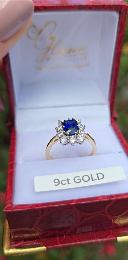 The sapphire cluster ring upright in its red Gleeson Jewellers box with “9ct GOLD” label.