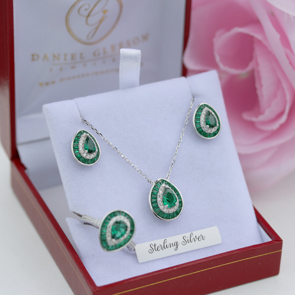 Jewelry set with emerald green stones in a red box with 'Gleeson Jewellers' branding.