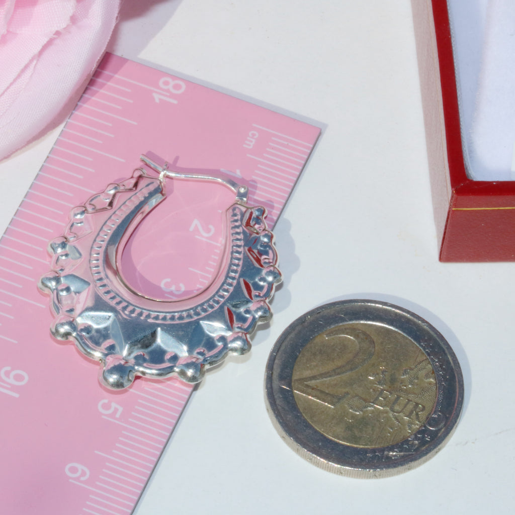 Sterling silver spike earring from Gleeson Jewellers shown beside a ruler and coin for scale.