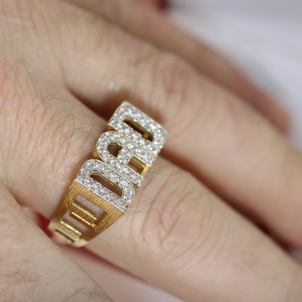Another hand-shot of the DAD Ring in natural lighting – Capturing the way the cubic zirconia stones catch the light, emphasizing the ring’s shine and bold presence.