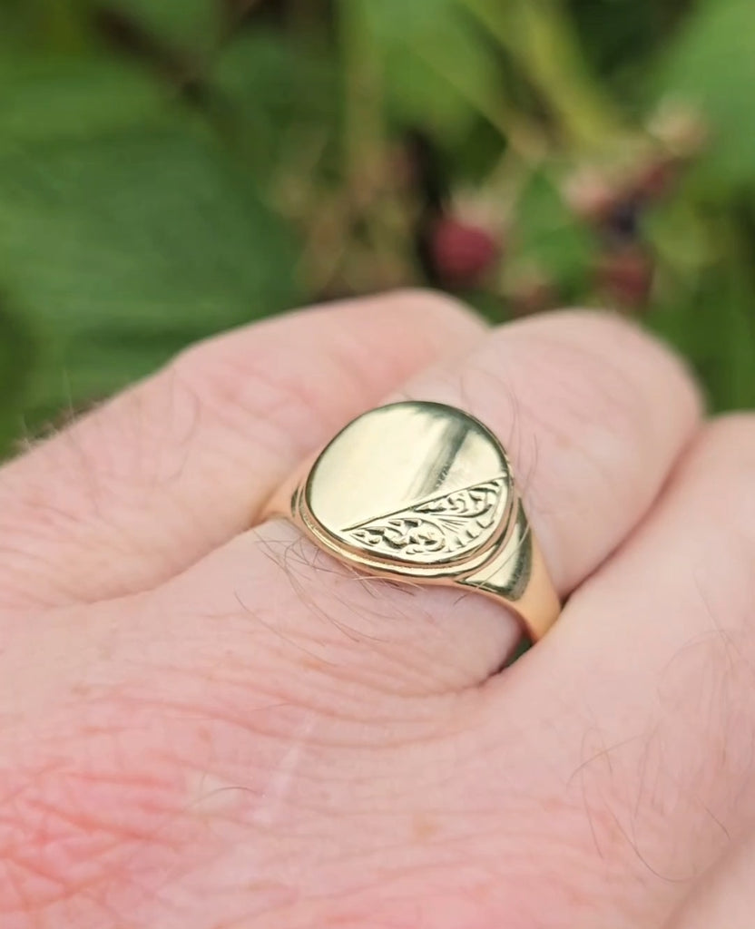 Chunky gold signet ring with half-engraved detail, worn on finger – Gleeson Jewellers