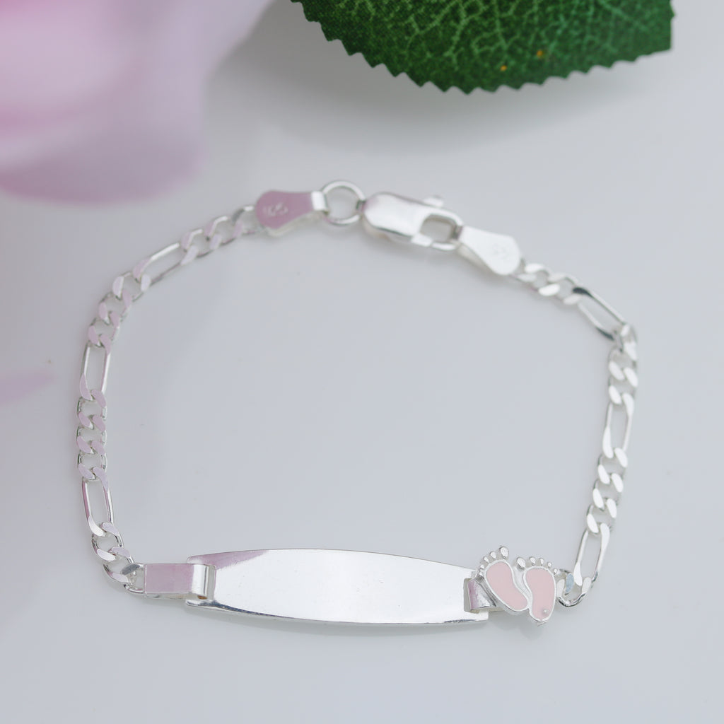 Sterling silver 6.5-inch children’s Figaro ID bracelet with smooth plate and pink enamel baby feet, displayed on a white background with green leaf detail.