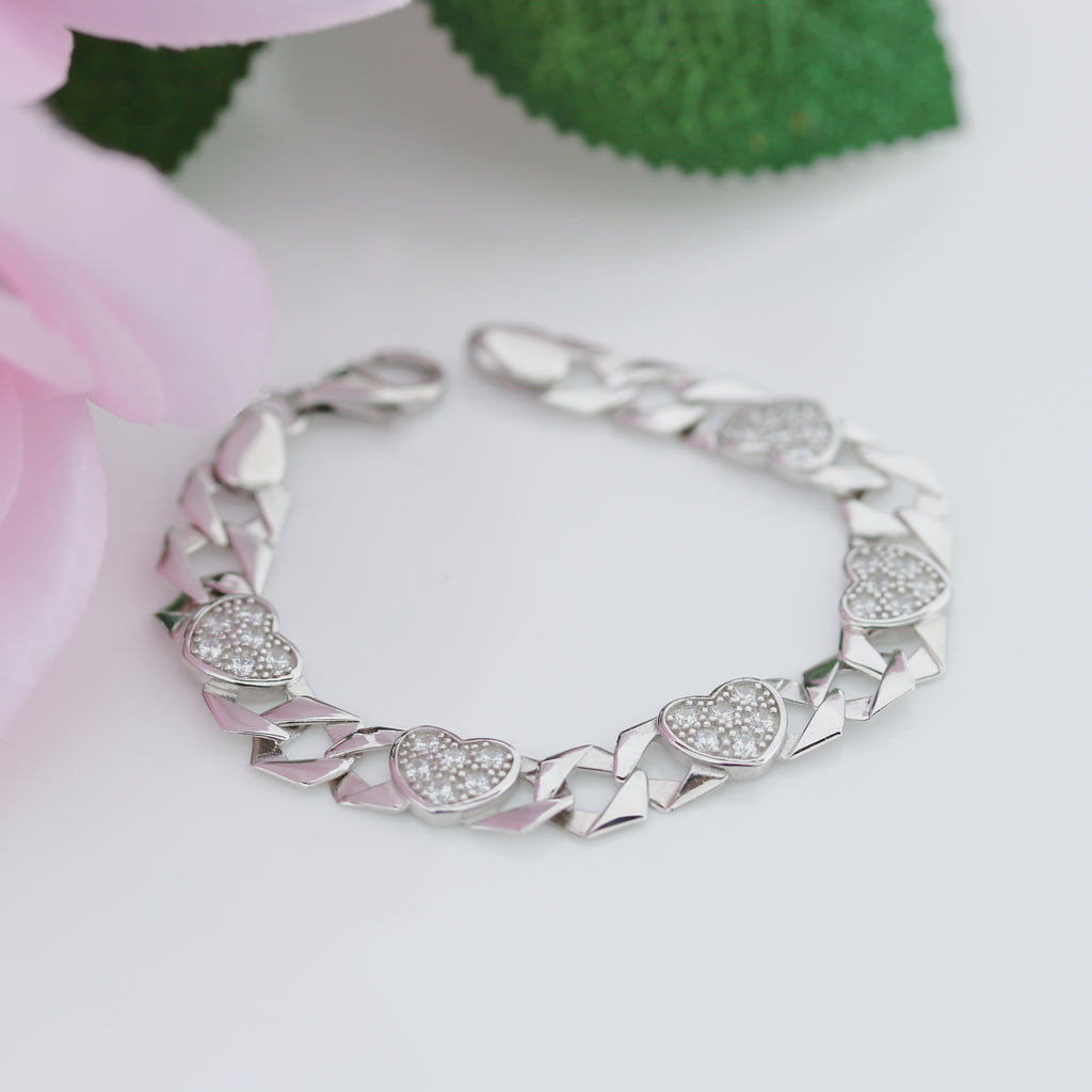 Silver bracelet with heart-shaped charms on a light background