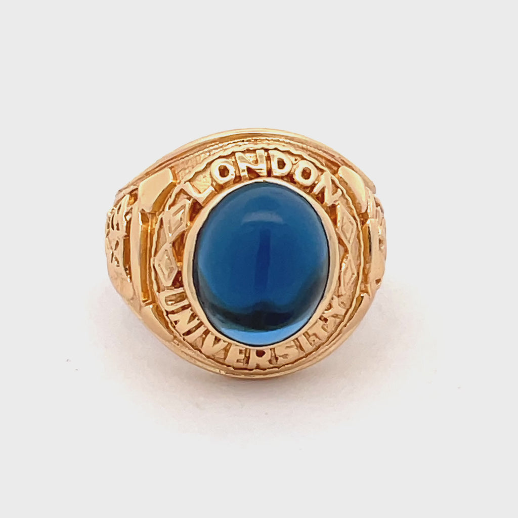 Front view of men’s sterling silver gold-plated college ring with oval blue stone centrepiece.