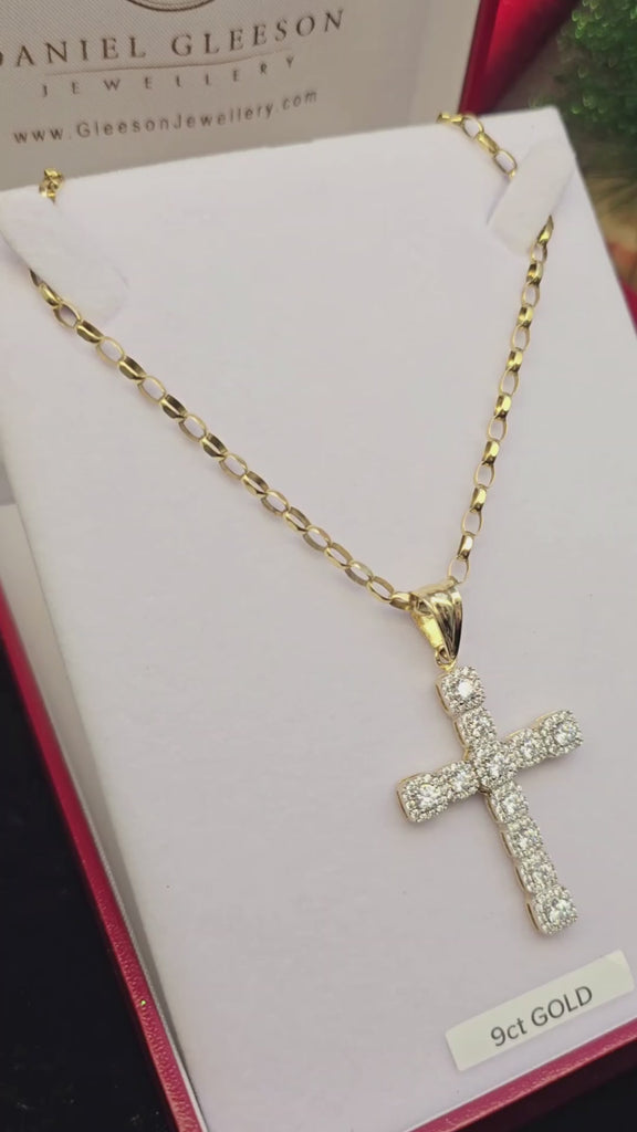 Video close-up of sturdy gold cross pendant with halo-set stones on belcher chain in a gleeson jewellers gift box and also demonstrated on the hand for size context.