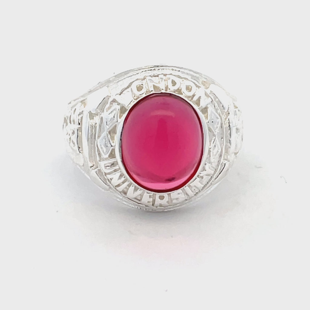 Overhead view of sterling silver men’s college ring with engraved detailing and red stone from Gleeson Jewellers.