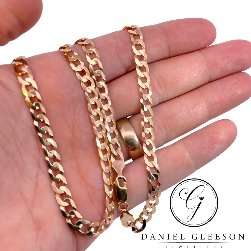 Gents gold 20" Curb flat link chain displayed on mans hand for size context