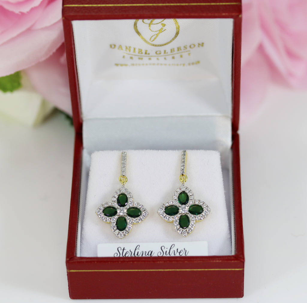 Sterling silver emerald and cubic zirconia cluster drop earrings with a 14-carat gold vermeil finish, elegantly displayed in a Daniel Gleeson Jewelers branded jewelry box, showing the intricate clover design and stud back closure