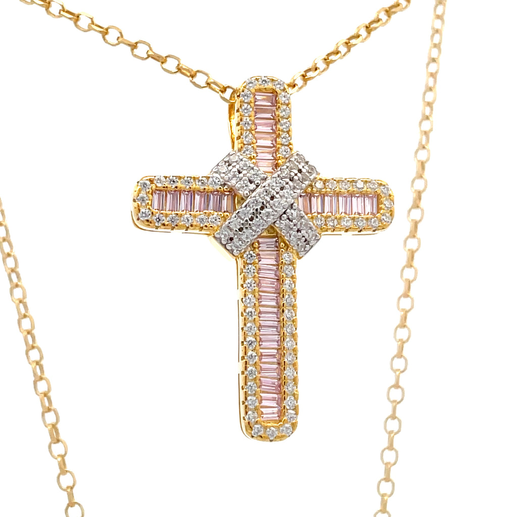 Angled view of sterling silver gold plated kiss cross pendant with pink baguette stones on belcher chain.