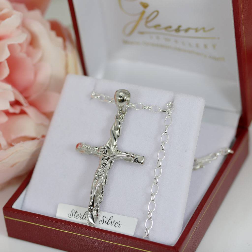 Elegant sterling silver crucifix pendant with a 20-inch oval link belcher chain, resting in a luxurious jewellery gift box