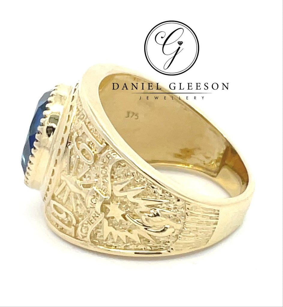 side profile of a mens college ring with detailed design on shoulders and shank of the ring and a beautiful royal blue stone in the middle supplied from Daniel Gleeson Jewellers