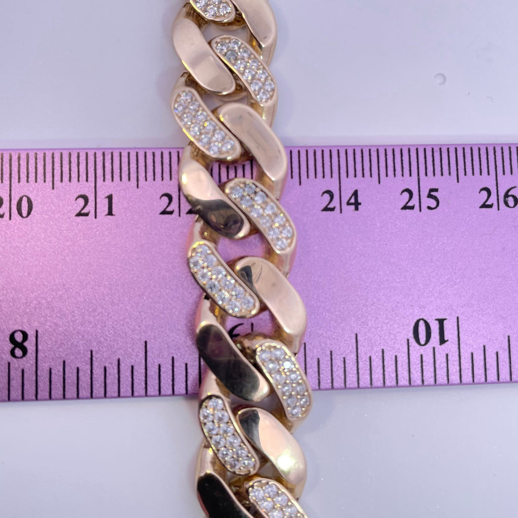 curb cz mens gold bracelet lying across a ruler to show the width of the bracelet 
