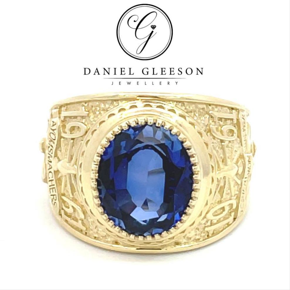 college ring with detailed design on shoulders and shank of the ring and a beautiful royal blue stone in the middle supplied from Daniel Gleeson Jewellers