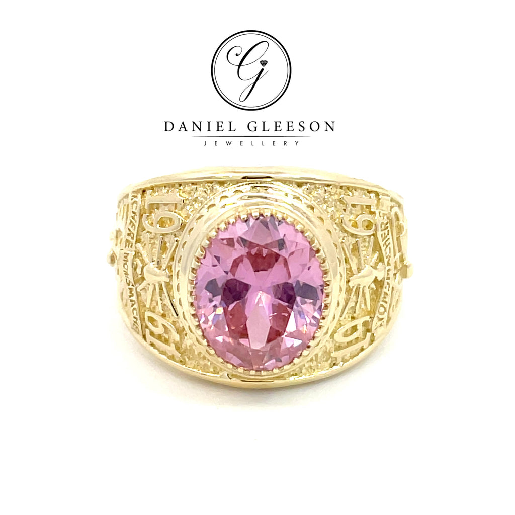 Front on picture of a pink glassy stone college ring set in 9ct yellow gold, amazing detailing on the sides 